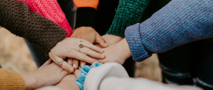 A group of people placing their hands in a circle all together