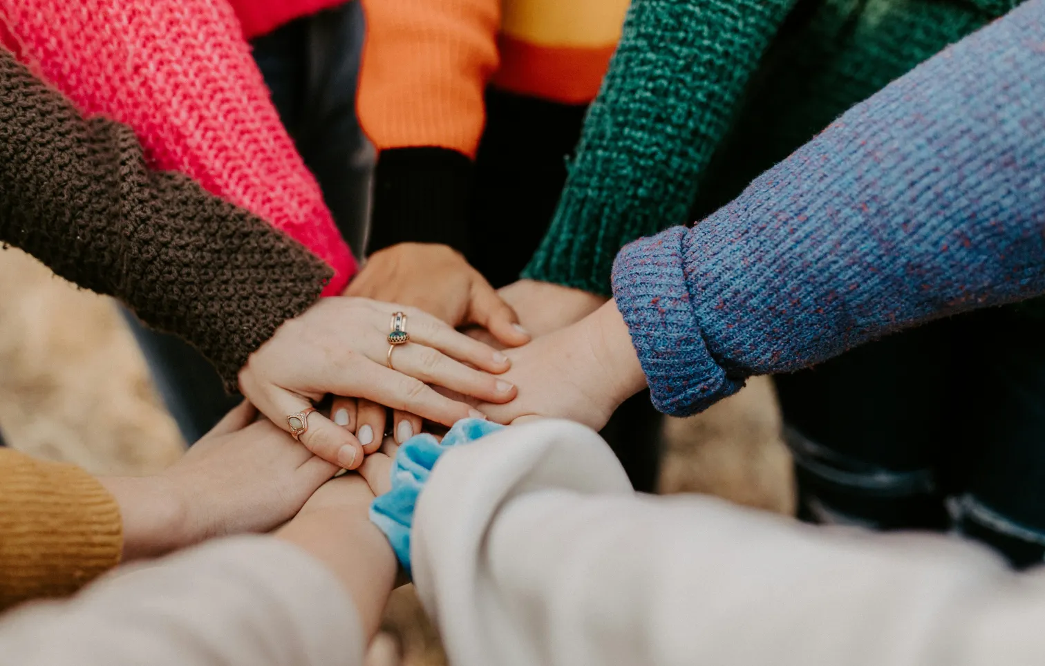 A group of people placing their hands in a circle all together