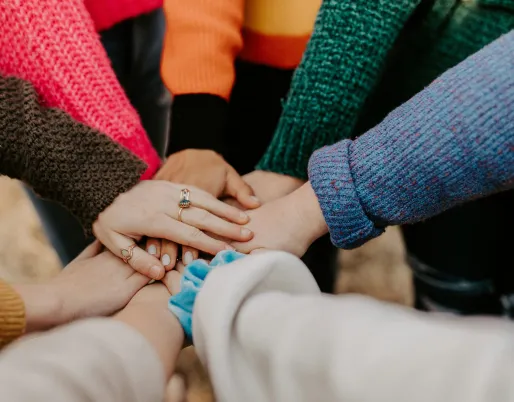 A group of people placing their hands in a circle all together